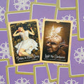 tarot kortos dviejų kortų ištrauka: „Stolen in Her Sleep“ ir „Light the Darkness“ ant violetinio fono, fotografuota iš viršaus