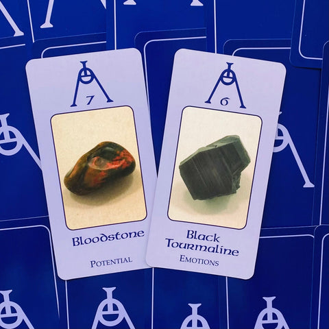 kristalai: Bloodstone (raudoni ir žali tonai) ir juodasis turmalinas ant tamsiai mėlynos kortelių fono, skirti intuicijai
