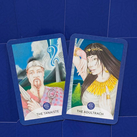 tarot kortos dvi iliustruotos kortos The Tanaiste ir The Adultrach su mėlynu rėmeliu, plokščiai išdėstytos