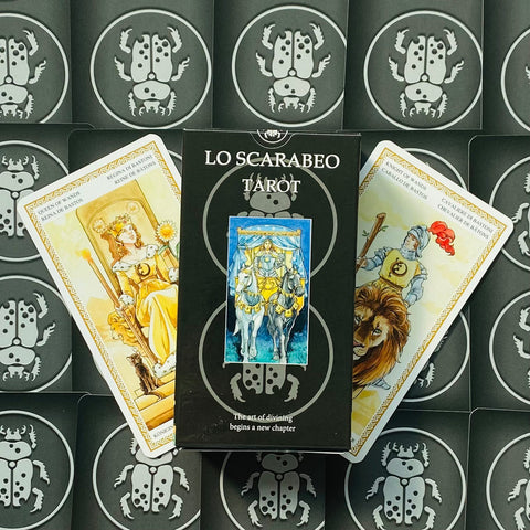 Lo Scarabeo tarot kortos juodoje dėžutėje, centre dėžutės priekinis viršelis ir dvi atverstos kortos šone