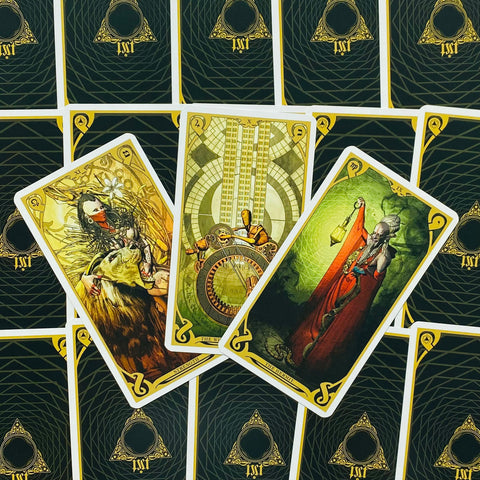 Tarot kortos su auksiniu–žaliu dizainu, trys atverstos didžiosios arkana: Stiprybė, Ratas ir Hermitas