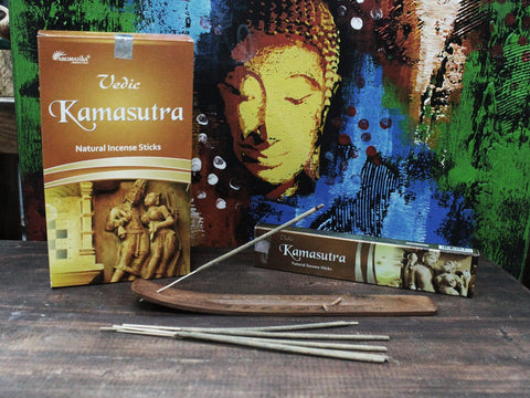Smilkalai Aromatika Kamasutra rudos pakuotės — stovinti ir gulinti dėžutė su keliomis lazdelėmis ant medinio laikiklio, paprastai demonstruoja produkto dydį ir dekorą