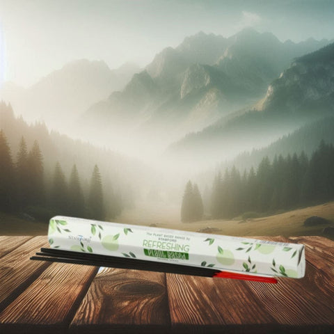 Kvapniosios lazdelės Refreshing baltame lapų raštų dėkle ant medinio stalo, juodos lazdelės su raudonu galu