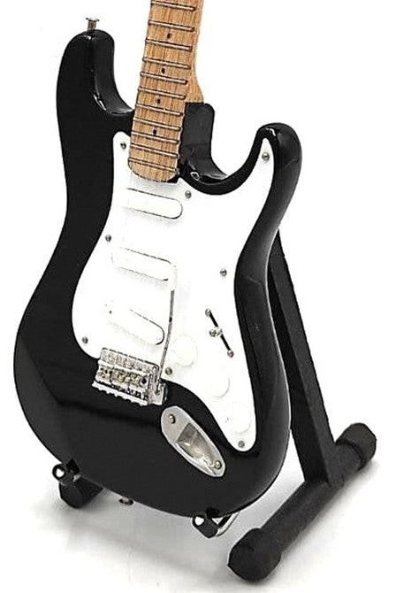 Elektrinė gitara juoda su balta apsaugine plokštele ir ąžuolo spalvos kaklu, rodoma iš arti ant stovelio parduotuvės puslapyje