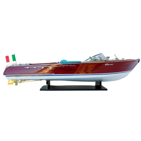 Riva motorinė valtis su blizgiu mahagonio korpusu ir mėlyna sėdyne, šoninis profilio kampas ant stovo su Italijos vėliava