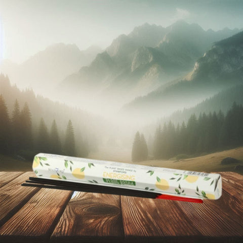 Kvapniosios lazdelės Energising (citrina) baltame dėkle su juodomis lazdelėmis, ant medinio stalo, kampiniu kadravimu