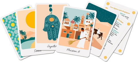Orakulo kortos su pastelinėmis iliustracijomis, centre Maroko tipo scena su Hamsa pakabuku ir instrukcijų lapais