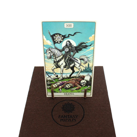 Tarot korta Mirtis, spalvota iliustracija ant mažo medinio stovo, eksponuota ant rudo FANTASY PUZZLES vilnos kilimėlio