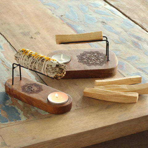 Smilkalų laikiklis medinis su mandalos graviruote ir tealight anga, rodomas su balto šalavijo pakuote ir palo santo lazdelėmis, skirtas staliniam naudojimui