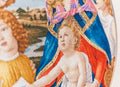Siuvinys – detali artimųjų planas su Madonos ir kūdikio veidais, aukso siūlų aureolėmis ir ryškiomis mėlyna‑raudona spalvomis