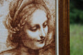 paveikslas sepijos atspalvio portreto fragmentas su medine rėmo briauna, arti parodomos veido ir plaukų detalės