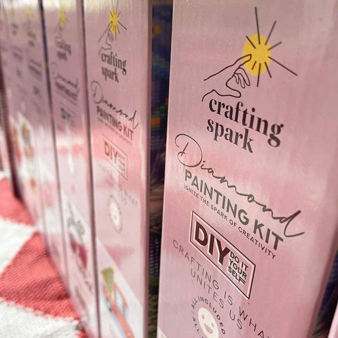 Diamond painting rinkinys Crafting Spark rožinėje dėžutėje, arti nufotografuotas priekiniu kampu lentynoje šalia kitų variantų
