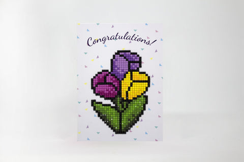 Atvirukas su geltonais ir violetiniais tulpių mozaikos žiedais, žėrinčiomis kristalėlių detalėmis ir užrašu "Congratulations" viršuje