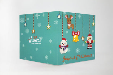 Kalėdinis atvirukas, sulankstytas žalsvo fono su kabinančiomis pikselių dekoracijomis (sniego senis, elnias, varpelis) ir užrašu Joyous Christmas