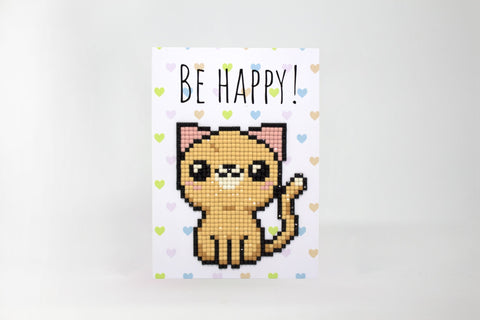 Atvirukas su rudos spalvos pikseliniu kačiuku iš blizgių deimantėlių, pastelinėmis širdelėmis fone ir užrašu „Be Happy“ viršuje