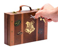 Lagaminas stilingas rudas Hogwarts stiliaus dėklas su auksiniu herbu ir lipdukais, rankos atidaromas užsegimas