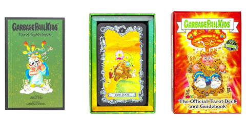 Garbage Pail Kids tarot rinkinys – žalias vadovas, viduryje atvertas kortų dėklas su „The Fool“ korta ir ryški oranžinė dėžutė