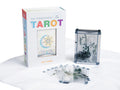 Skaidrus tarot rinkinys Emily Carding: baltas dėklas su spalvotu logotipu, plastikinė dėžutė ir išskleistos permatomos kortos