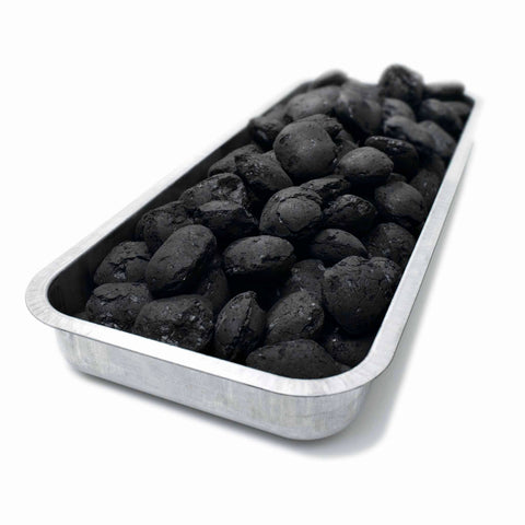 Medžio anglies briketai juodi, aptaškyti pelenais, 2 kg dėžėje ant aliumininės skardos iš arti, idealiai tinka kepsninėms