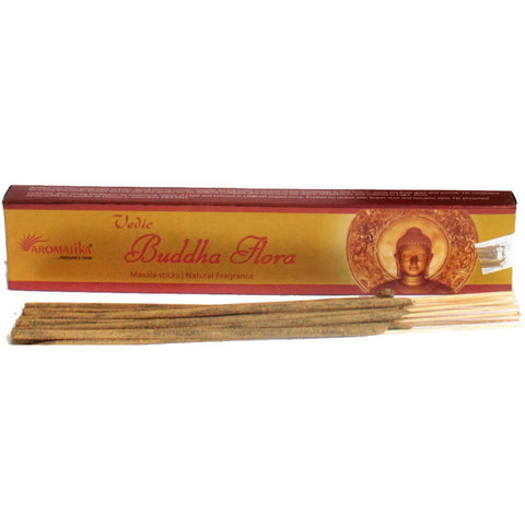 Smilkalai Aromatika Buddha Flora, masala rudos lazdelės išdėstytos prieš gelsvai‑raudoną dėžutę su Budos motyvu