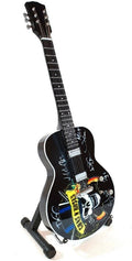 Gitara — juoda elektrinė su Guns N' Roses kaukole ir kelių narių autografais, matoma iš priekinio kampo