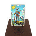 tarot korta The Fool spalvota, stovi priekyje ant medinio stovelio ant rudos vilnos pagalvėlės su Fantasy Puzzles logotipu