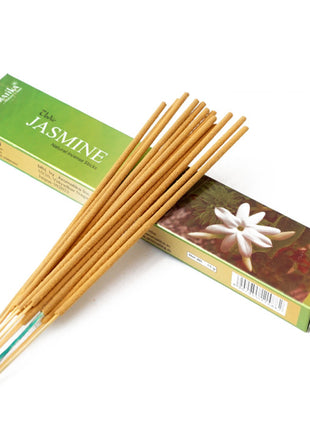 Jazminų smilkalai ant žalios pakuotės, ilgos lazdelių kuokštelis pabrėžia jų tekstūrą ir aromatą