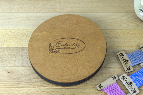Siuvinėjimo dėžutė iš šviesaus medžio su graviruotu Embroidery Craft dangčiu ir plonu profiliu, rodoma kartu su siūlų kortelėmis