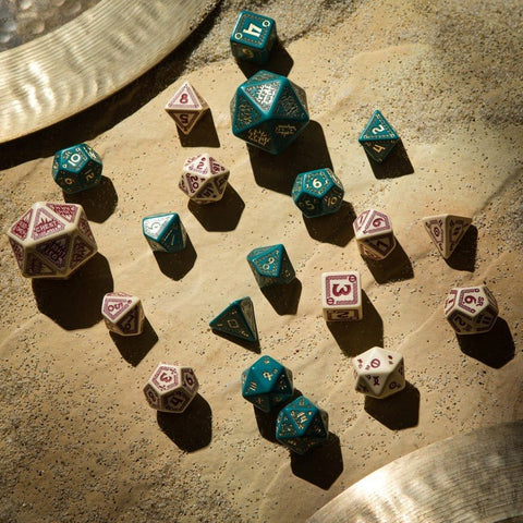 RPG kauliukai, turkio ir kreminės 7 dalių rinkinys su auksiniais skaitmenimis, išdėstyti iš viršaus ant tekstūruoto pagrindo