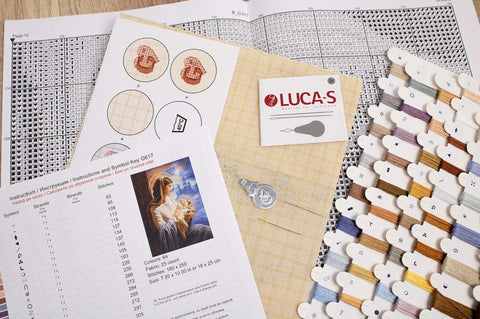 Siuvinėjimo rinkinys Luca‑S su gelsvos spalvos linu, spalvotomis siūlų kortelėmis, simbolių lentele ir adatomis