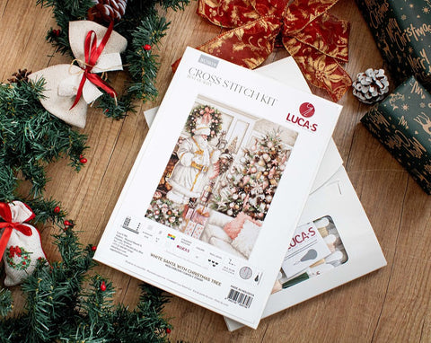 Kryželių rinkinys Luca‑S „White Santa with Christmas Tree“, komplekte siūlai ir priedai, plokščiai išdėstytas šventiniame fone