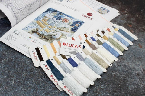 Siuvinėjimo rinkinys Lucas su išdėstytais daugiaspalviais siūlais ir schema kalėdinei sniego scenai