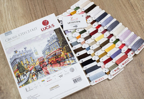 Kryželių rinkinys Lucas London su išdėstytomis daugiau nei 40 daugiaspalvėmis siūlų kortelėmis ir miestelio dizainu
