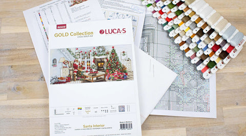 kryželių rinkinys LUCA‑S Santa Interior su daugiarašiais siūlais, siūlų kortele, schema ir audiniu ant stalo