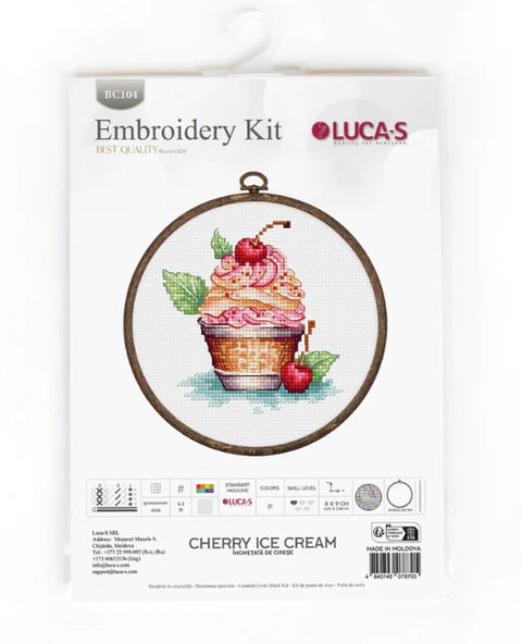 Siuvinėjimo rinkinys Lucas Cherry Ice Cream su apvaliu rėmeliu, kryželių dizainu: vyšnių ir ledų keksiukas ant baltos drobės