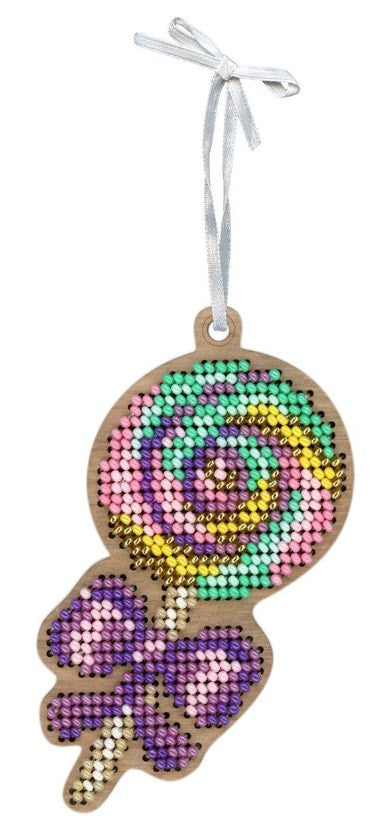 Kalėdinė dekoracija – medinė saldainio formos pakabėlė su pastelinėmis karoliukų spiralėmis ir violetine kaspine