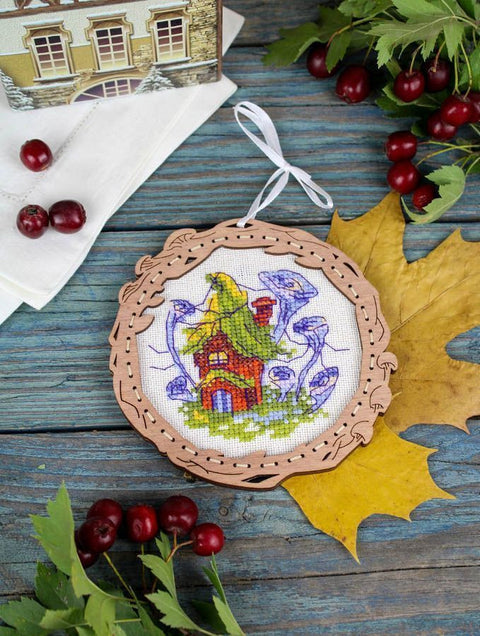 Siuvinėtas medinis ornamentas su rankų darbo grybų‑namu raštu, baltu drobės fonu ir balta pakabinimo juostele