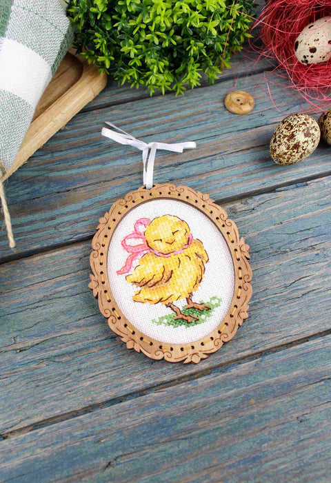 Siuvinėtas medinis rėmelis–ovalus pakabukas su geltonu viščiuku ir rožine kaspina, 7×9 cm, priekinis artimas kampas