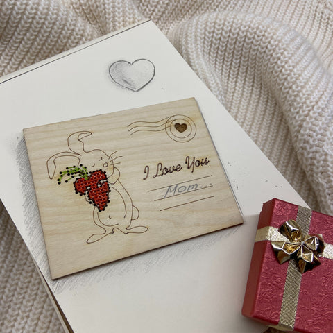 Medinė atvirutė su raudona karoliukų braškės širdimi ir zuikučio piešiniu, su graviruotu I Love You Mom užrašu