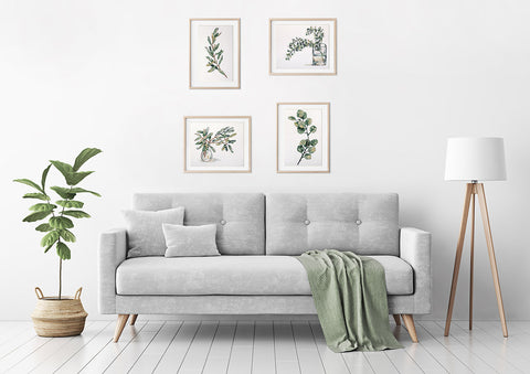 Pilka trijų vietų sofa su medinėmis kojelėmis, žalsvu pledu ir pagalvėlėmis, parodyta moderniame svetainės aranžuotėje