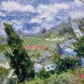 Kryželių rinkinys artimas planas: smulkūs siūlų kryželiai žalių ir mėlynų tonų peizaže, aiški tekstūra ir stitch detalė