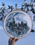 Kryželiu siuvinėjimas su mėlyno‑pilka žiemos pilimi mediniame 25 cm lankelyje, fotografuotas lauke ant sniego