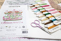 Kryželių siuvinėjimo rinkinys Letistitch 'Baby Carousel' su spalvotomis siūlų kortelėmis ir rožinėmis žirklėmis.