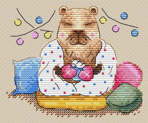 Siuvinėjimo rinkinys kapibara, pastelinės siūlės ir rožinės bei mėlynos pagalvės, laikanti puodelį ant 25×20 cm drobės
