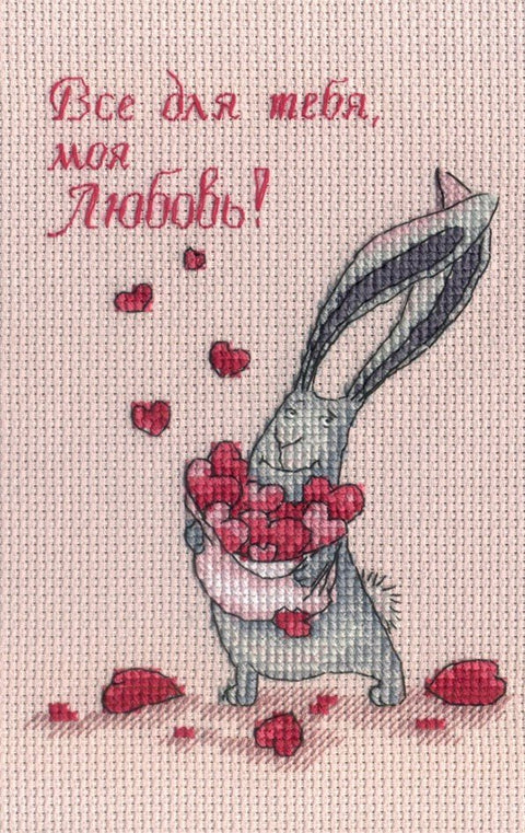 Siuvinys – žaismingas triušis laikantis raudonas širdeles ant šviesiai rožinio fono su rusų užrašu Все для тебя, моя любовь