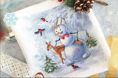 Kryželiu siuvinys 20×20 cm, žieminis pastelinių mėlynų atspalvių su besmegeniu ir elniuku, arti, plokščias kampas su kankorėžiu ir nėriniu