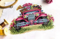 Siuvinėjimo rinkinys rožinio retro automobilio motyvu, arti parodytas detalus kryželių raštas su siūlais ir lankeliu