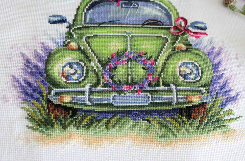 kryželių rinkinys: žalias retro automobilis iš arti su levandomis ir rožiniu gėlių vainiku, detali priekinė kompozicija