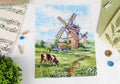 Kryželių rinkinys vėjo malūnai, mėlyna sodyba 30×40 cm, užbaigtas ant drobės, plokščias išdėstymas su sagomis ir natų lapu