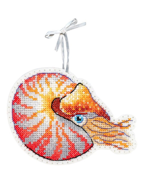 Siuvinėtas pakabukas nautilusas, oranžinės, raudonos ir pilkos spalvų kryželių raštas, su sidabrine juostele kabinimui